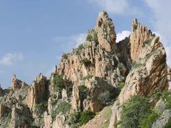 MS Shot of car on the road through the fantastic rock landscape of the Calanche of Piana, UNESCO World Heritage Site / Gulf of Porto, Corsica, France Stock Footage