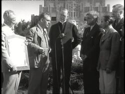 A man presents Father Flanagan, founder of Boys Town, with a humanitarian award. News Clip