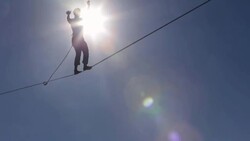 Man traverses highline stretched above sea below Stock Footage