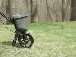 Woman Fertilizing Yard with Wooded Background Stock Footage