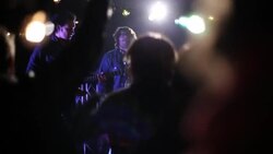 Wide pan of concert stage from behind crowd Stock Footage