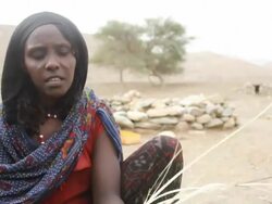 Woman with tattooed face braiding straw Stock Footage