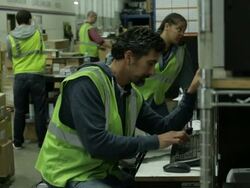 Four warehouse employees busily work moving boxes and filling orders. Stock Footage