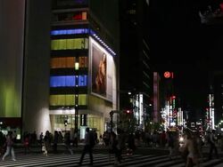 MS Shot of Busy city scene with pedestrians and traffic at night with street lights and neon retail signs in Ginza / Tokyo, Japan Stock Footage