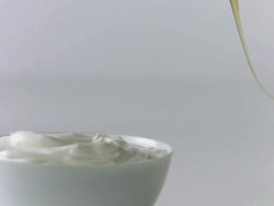 Honey drizzled over yogurt from honey dipper Stock Footage