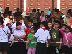 WS SLO MO Uniformed kids holding striped sticks horizontally at school ground / Vientiane, Laos Stock Footage