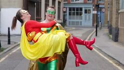Laughing superhero carrying wife in city Stock Footage