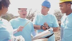 Construction foreman instructing volunteers as the build home for charity Stock Footage