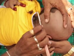 Barber shaving head of a baby, Haridwar, Uttarakhand, India Stock Footage