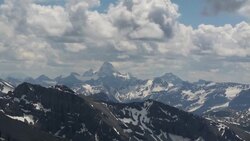 Time-Lapse pan of clouds billowing over distant mountains Stock Footage