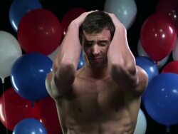 Man with head in hands with balloons in background Stock Footage