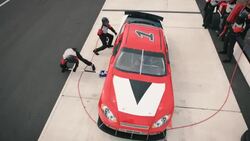 Stock car pit-crew jackman lowers race-car Stock Footage