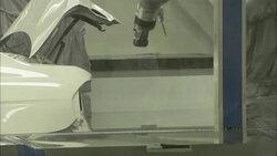 Robotic arms open the doors and the trunk of a car shell on an assembly line in an automobile factory. Stock Footage