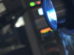 ECU digital cinema projector lens and moving image reflections in movie theater projection booth Stock Footage