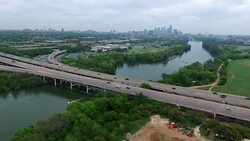 Zilker Park Clubhouse View Austin Texas Greenbelt area next to Colorado River Town Lake and Mopac Extrpessway with boats driving on a cool misty cloudy morning Stock Footage