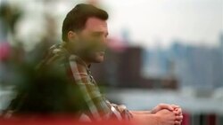 Hip young man stands alone on Brooklyn rooftop (dolly-shot) Stock Footage