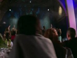 TRACKING WS Wedding guests dance on stage while others watch from tables Stock Footage