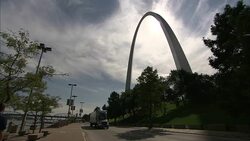 A truck and a solitary pedestrian pass the Gateway Arch in St. Louis. Stock Footage