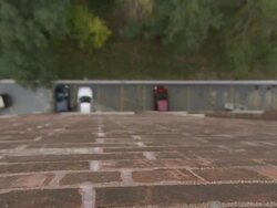 High Angle soft-focus zoom-out - Vehicles park in a lot below a brick building. / Wisconsin, USA Stock Footage