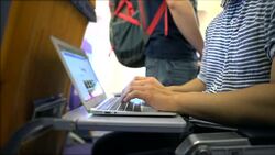 Young man is working on a laptop on an airplane Stock Footage