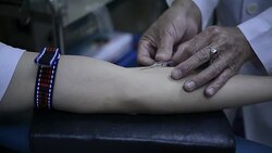 technician inserts needle into blood donor's arm, taking blood tests in blood bank laboratory in hospital Stock Footage