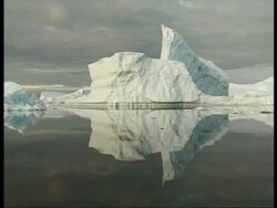 MS large iceberg floating and reflected in glassy, still water, Antarctica Stock Footage
