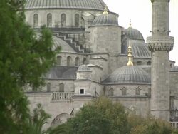 Low Angle tilt-up - Pedestrians loiter in a park adjacent to Hagia Sophia. / Istanbul, Turkey Stock Footage