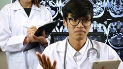 Male doctor on video call from her Office with X-ray image of the brain computed tomography on Background Stock Footage