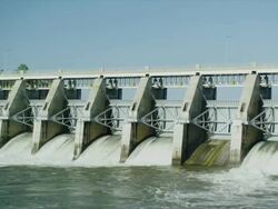 WIde shot of Water spillway behind electricity generating dam Stock Footage
