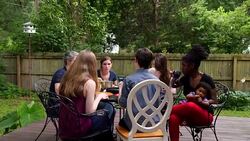 MS PAN Family eating dinner on backyard patio on summer evening Stock Footage