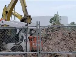 Heavy equipment trucks and tractors move and sort scrap pile debris for recycling in junk yard. - 3 Stock Footage