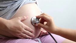 Doctor use stethoscope to hear belly of pregnant woman Stock Footage