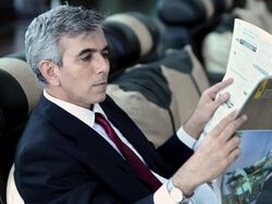 MS PAN Businessman reading newspaper at airport / India Stock Footage