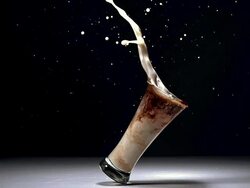 MS SLO MO Glass of beer splashing and falling gainst black background / Vieux Pont, Normandy, France Stock Footage