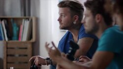 Guys sitting on couch playing video games Stock Footage