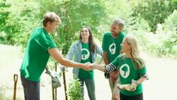 Environmentalist volunteers handshaking and planting trees Stock Footage