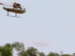 WS PAN Man in helicopter with tranquilizer gun / Save Valley,Southern Zimbabwe,Zimbabwe Stock Footage