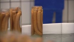 Frankfurters fill jars that move along a conveyor. Stock Footage