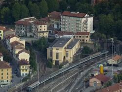 Exterior day shot zooming out from far away of the city and a train slowly moving out of view Stock Footage