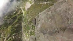 POV wingsuit jumping off cliff and slow motion flying through clouds and over rock spires Stock Footage