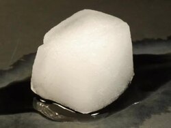 T/L Ice cube melting on dark surface Stock Footage