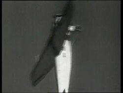 Black and white tracking shot of propeller airplane doing loop in air at air show / NO AUDIO Stock Footage