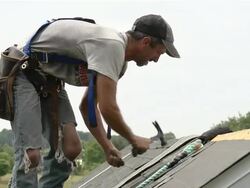 MS Shot of worker hammering at top of roof / Chelsea, Michigan, United States Stock Footage