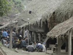 WS people sitting outside huts / Xam Neua, Laos Stock Footage
