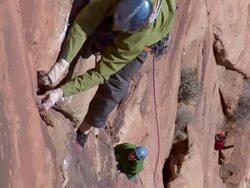 MS Looking down on climber high above the ground and Cllimber in struggling to make next move / Zion,UT,USA Stock Footage