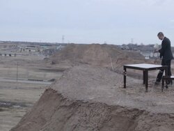 MS Young businessman in black suit setting lamp on  table on top of  bluff in rural area  / Maple Grove, Minnesota, United States Stock Footage