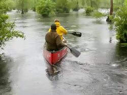 WS TU Shot of two men's paddling boat in swampy river in rain / Manteo, North carolina, United states Stock Footage