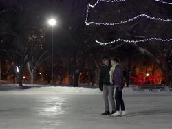Couple has skating date on a snowing winter evening. Stock Footage