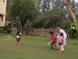 Senior man playing cricket with his grandchildren in holi festival  Stock Footage