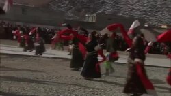 Costumed dancers kick up dust as they perform a traditional Tibetan dance. Stock Footage